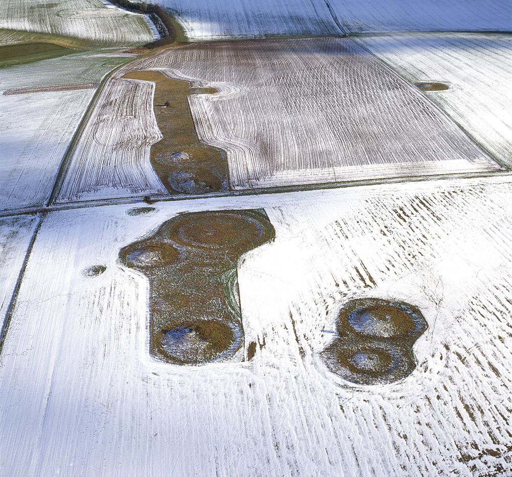 Aerial image of Normanton Down Barrows in snow, consisting of a Neolithic long barrow and Bronze Age round barrows, Wiltshire, England, United Kingdom, Europe