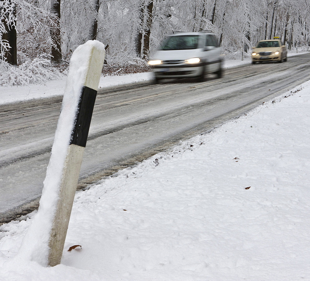 Snow-covered road in winter with traffic, Hesse, Germany, Europe