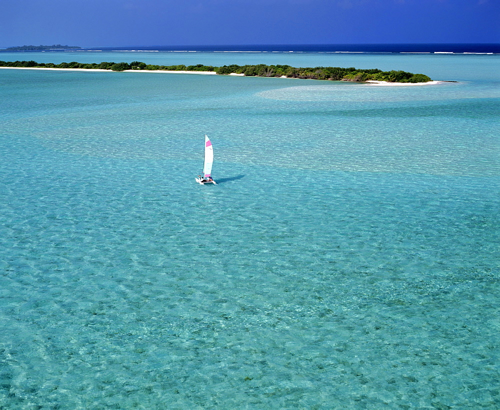 Catamaran in lagoon with island, aerial view, Maldives, Indian Ocean