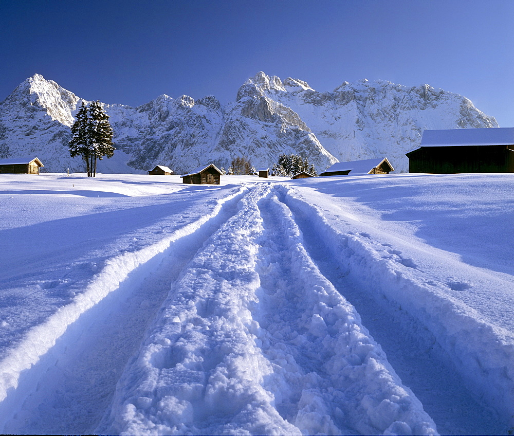 Snowy dirt track in winter, Karwendel mountains, Mittenwald, Upper Bavaria, Germany