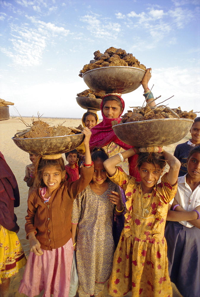 Women and children gathering dung for their cooking fires, near Khimsar, Rajasthan, India