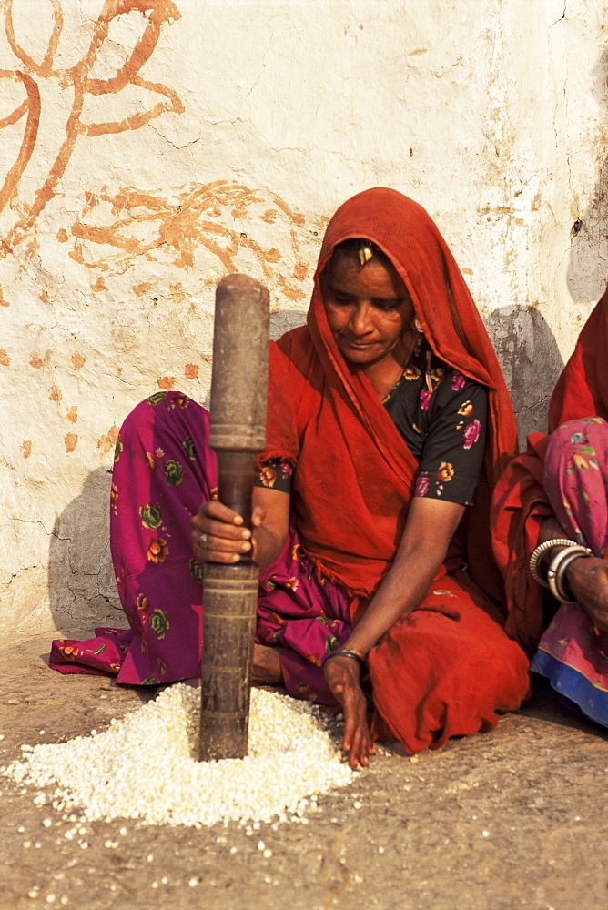 Woman pounding food in village near Deogarh, Rajasthan state, India, Asia