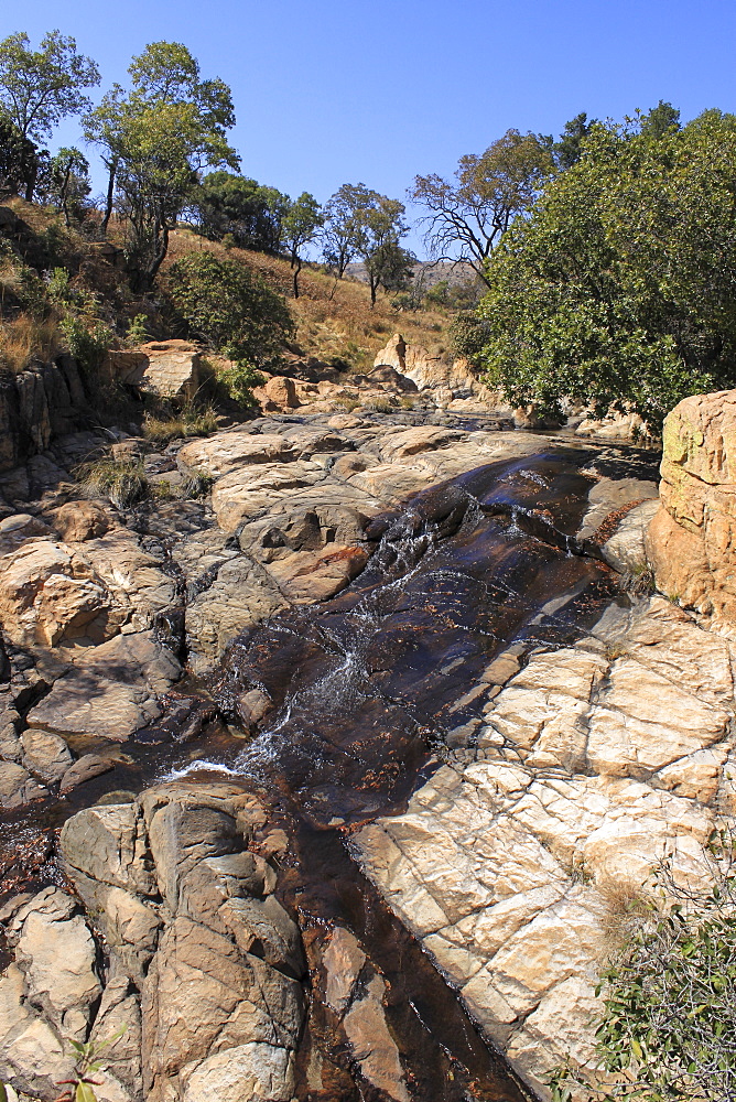 Water trickling over sand-coloured rocks, the Witwatersrand mountains, Magaliesburg, Gauteng, South Africa, Africa.