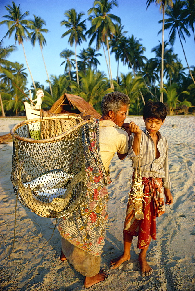 Fisherman with wicker basket and boy with shellfish, their morning catch, at Kemamaiy, east Malaysia, Southeast Asia, Asia