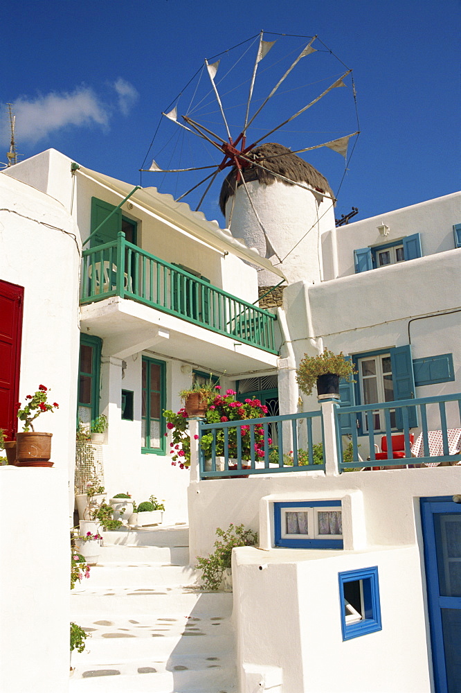 White house with windmill in the background on Mykonos, Cyclades Islands, Greek Islands, Greece, Europe