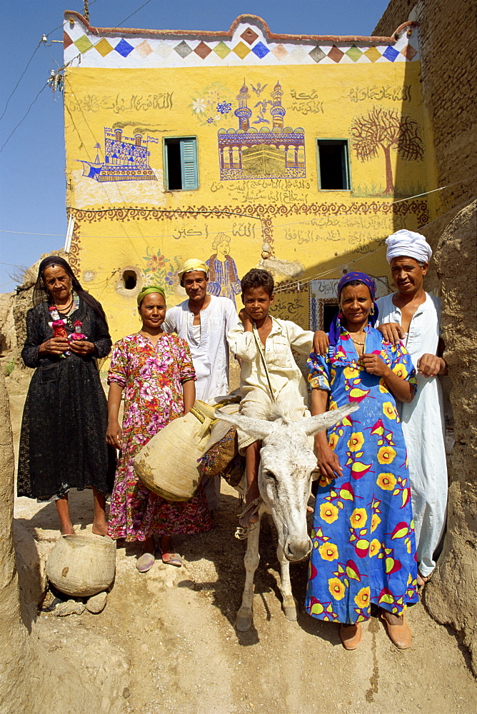 Portrait of a family, three generations, including a boy on a donkey, outside their painted house in the alabaster village of Dra Abul Naga, Egypt, North Africa, Africa