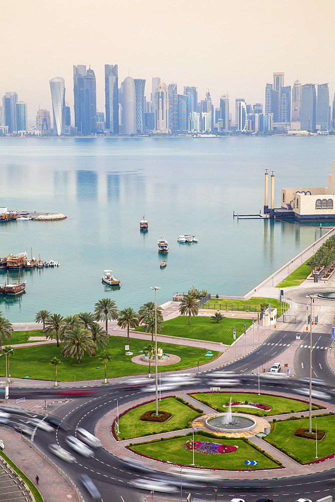 Traffic at roundabout in front of Museum of Islamic Art with West Bay skyscrapers in background, Doha, Qatar, Middle East