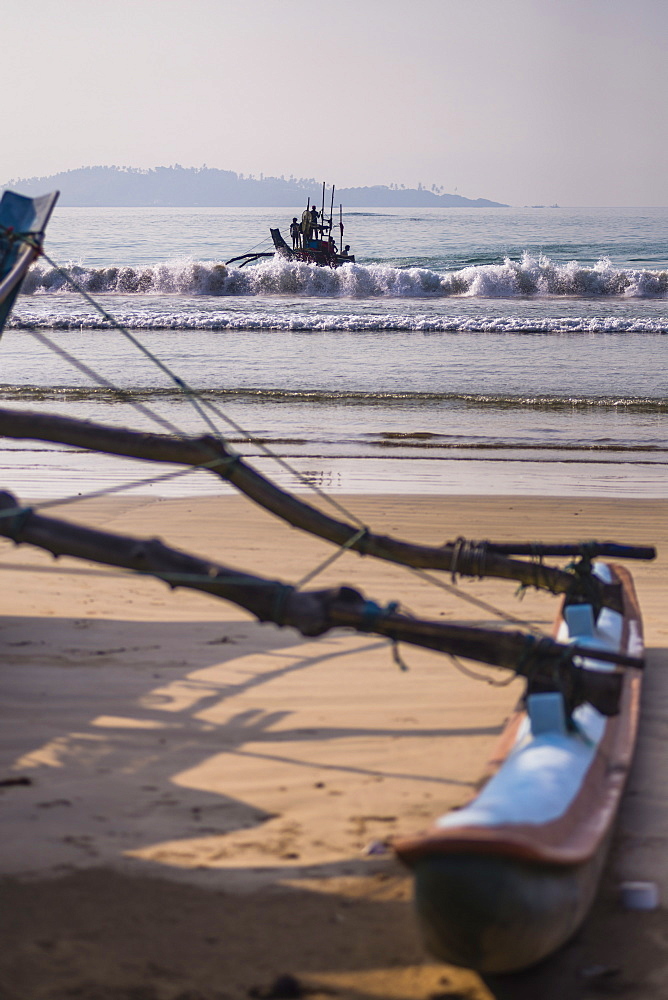 Weligama Beach, a fishing boat returning from sea on the South Coast of Sri Lanka, Indian Ocean, Asia