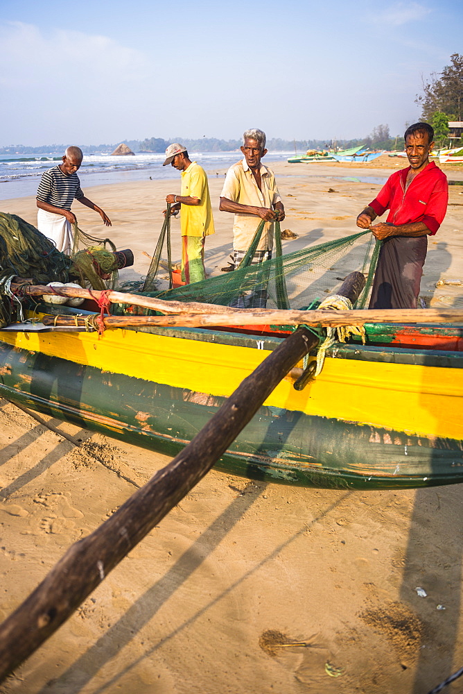 Fishermen sorting their catch on Weligama Beach, South Coast of Sri Lanka, Asia 