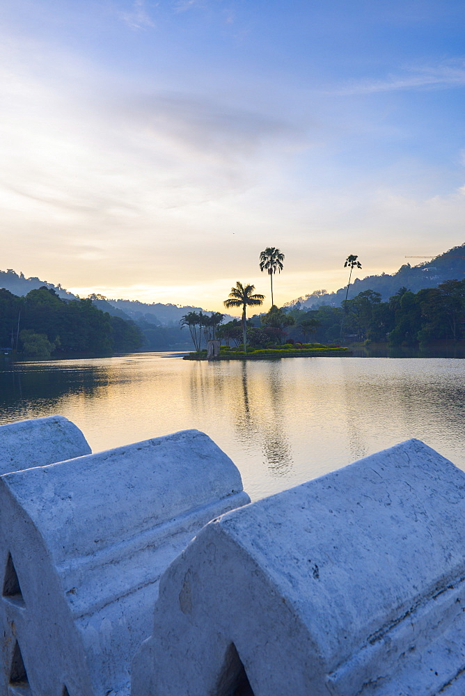 Kandy Lake at sunrise, the island of the Royal Summer House, with the Clouds Wall in the foreground, Kandy, Sri Lanka, Asia 