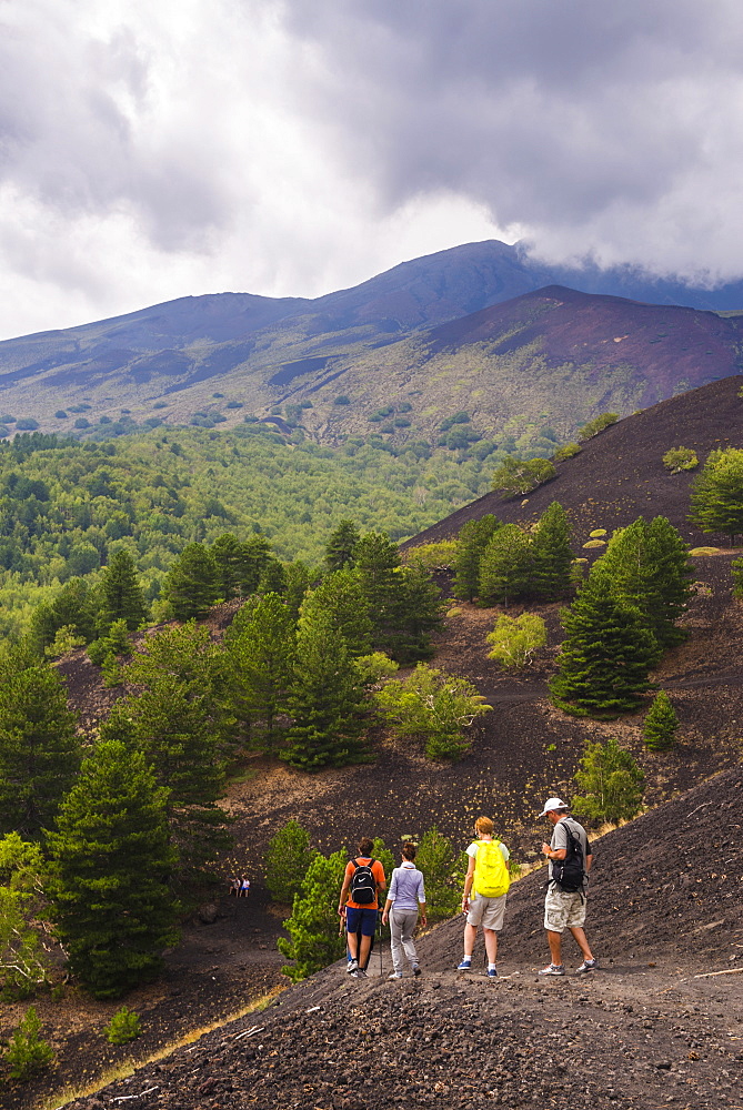 Tourists hiking on an old lava flow from an eruption, Mount Etna, UNESCO World Heritage Site, Sicily, Italy, Europe