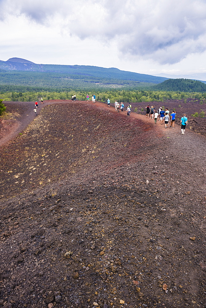 Tourists exploring an old lava flow from an eruption of Mount Etna Volcano, UNESCO World Heritage Site, Sicily, Italy, Europe 