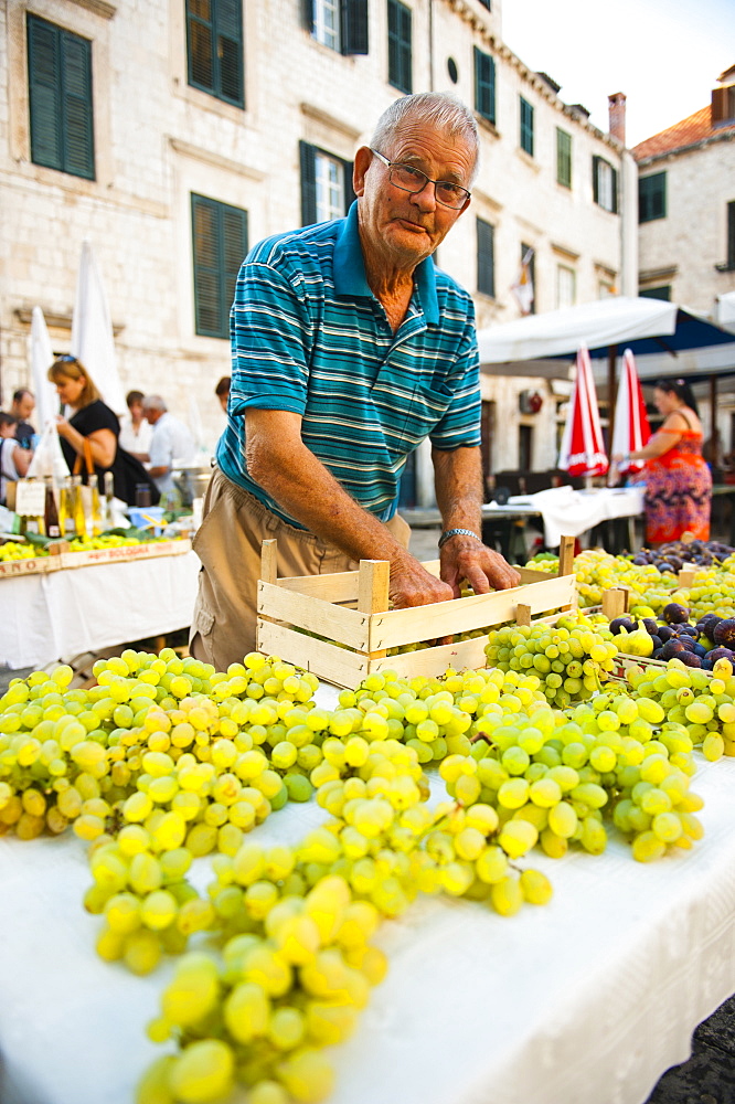 Vendor at Dubrovnik Market setting up his stall for Gundulic fruit market in Gundulic Square, Dubrovnik, Croatia, Europe