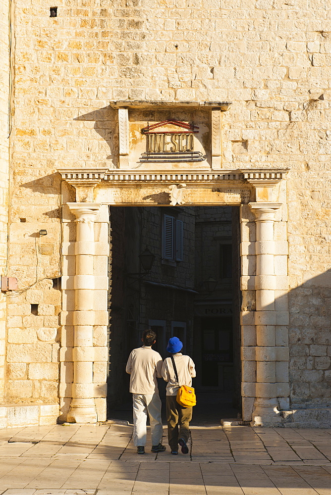 Tourist entering Old Town of Trogir through the South Town Gate, Trogir, UNESCO World Heritage Site, Dalmatian Coast, Croatia, Europe 