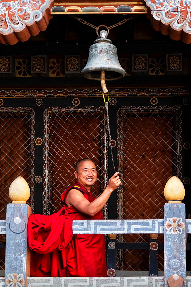 Buddhist monk ringing prayer bell, Trongsa Dzong, Trongsa, Bhutan, Asia