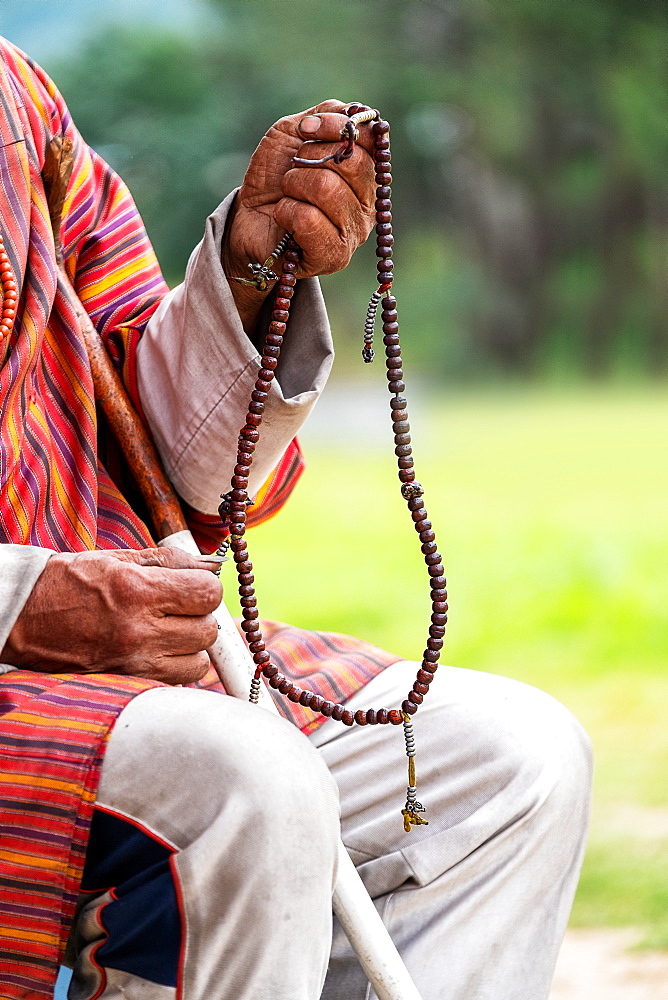 Close up of man holding Buddhist prayer beads, Bhutan, Asia