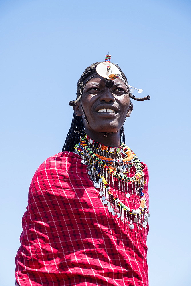 Portrait of a single Masai Mara man wearing traditional jewelry, headpiece and clothes, Masai Mara National Reserve, Kenya, East Africa, Africa