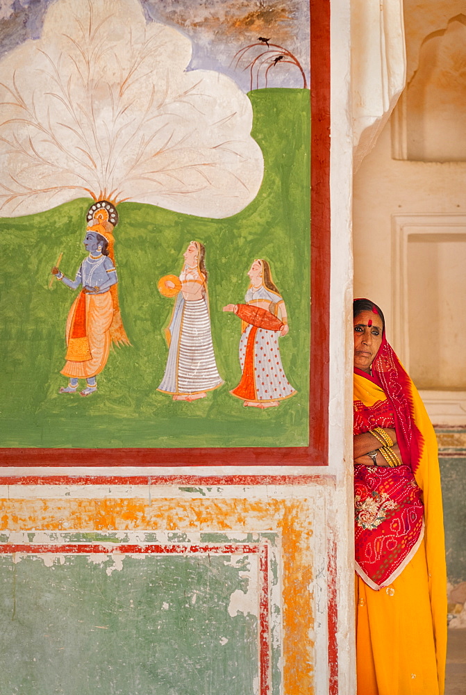 Hindu woman by artwork at Amber Fort in Jaipur, Rajasthan, India, Asia