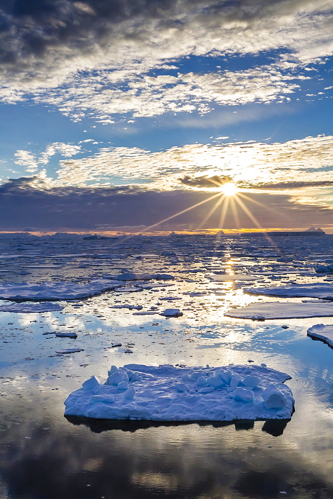 Sunset over ice floes and icebergs, near Pleneau Island, Antarctica, Southern Ocean, Polar Regions