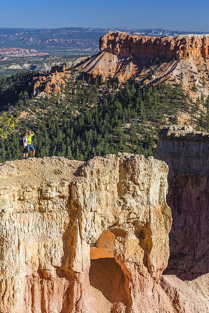 Hikers on arch rock formation in Bryce Canyon Amphitheater, Bryce Canyon National Park, Utah, United States of America, North America