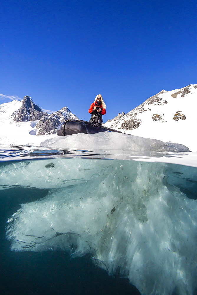 Above and below view of glacial ice and Zodiac in Orne Harbor, Antarctica, Polar Regions