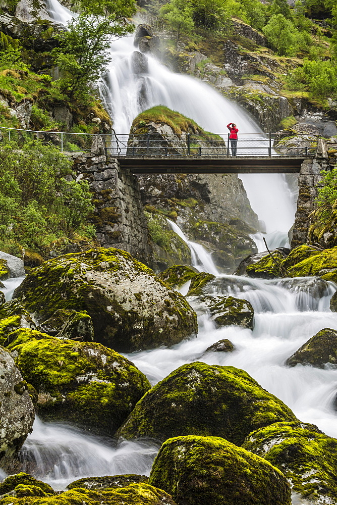 Slow shutter speed silky water of the Olden River and bridge as it flows along Briksdalen, Olden, Nordfjord, Norway, Scandinavia, Europe