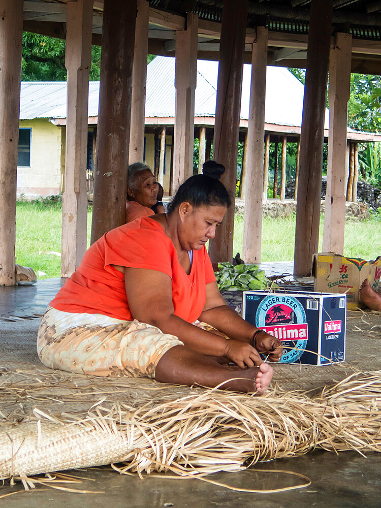 Woman with children weaving traditional mats in the town of Lufilufi on the island of Upolu, Samoa, South Pacific Islands, Pacific