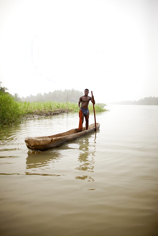 Man in a logboat fishing on Mono river, Agbanakin, near Grand-Popo, Mono Department, Benin