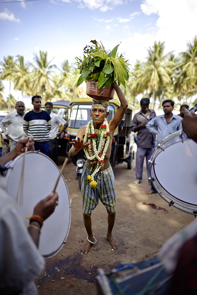 Pilgrim carrying holy water on his head while dancing, Mysore, Karnataka, India