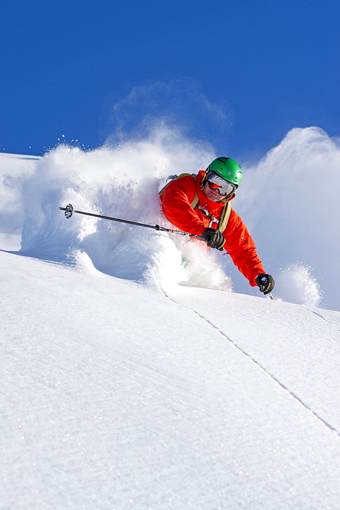 Closeup of a skier in waistdeep powder turning in front of the camera, Hochfuegen, Zillertal, Austria