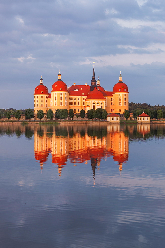 Panorama of the baroque Moritzburg castle in the evening sun with its reflection in the castle pond, near Dresden, Saxony, Germany