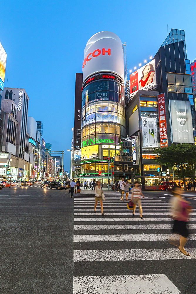 Zebra Crossing with moving women at Ricoh Imaging Square in Ginza during blue hour, Chuo-ku, Tokyo, Japan