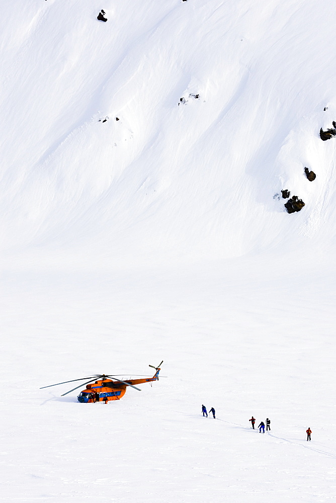 Group of skiers near a helicopter, Heliskiing, Kamchatka Peninsula, Sibiria, Russia