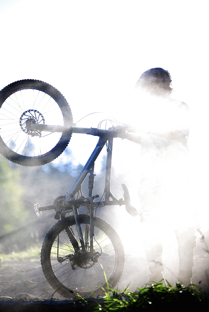 Young man holding a mountain bike, Oberammergau, Bavaria, Germany