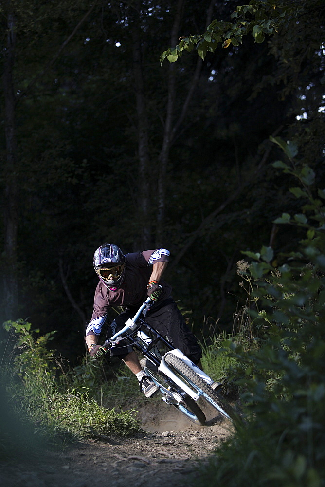 Mountain biker riding over forest track, Oberammergau, Bavaria, Germany