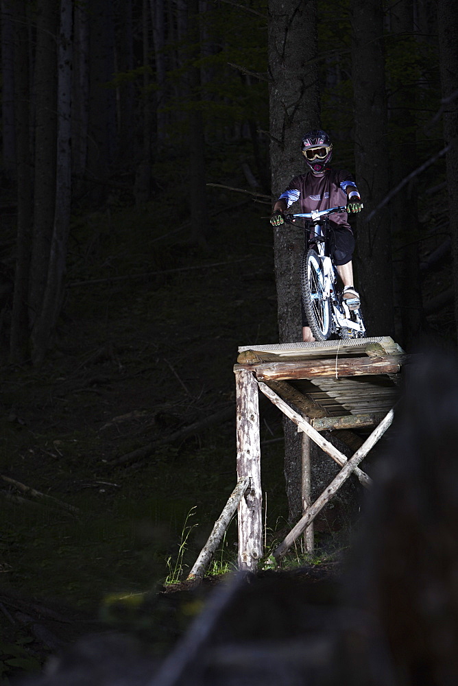 Mountain biker standing on ramp, Oberammergau, Bavaria, Germany