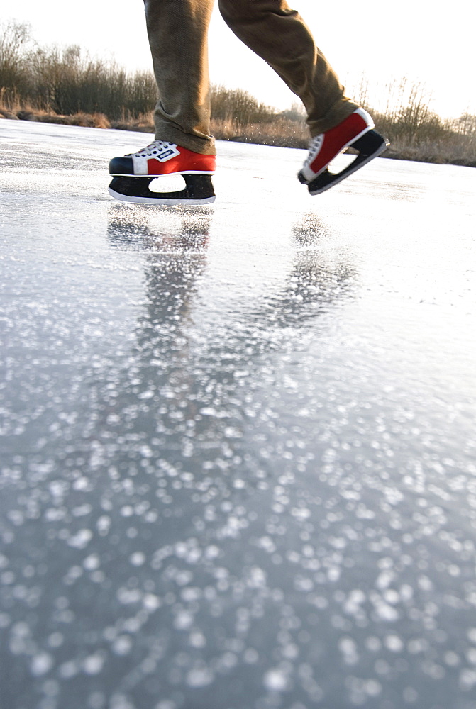 Man skating on lake Ammersee, Upper Bavaria, Germany