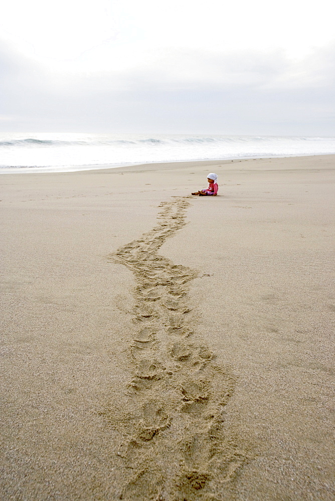 Child crawling over the beach, Punta Conejo, Baja California Sur, Mexico