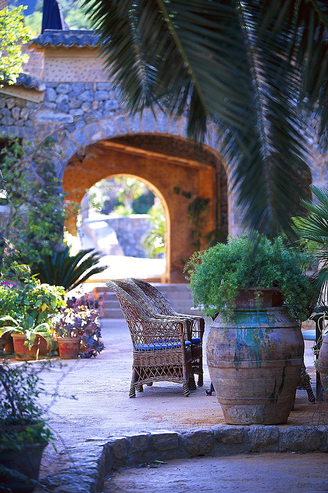 Basket-chair and plants at the courtyard of Finca Hotel de Reis, Valle de los Naranjos, Soller, Majorca, Spain, Europe