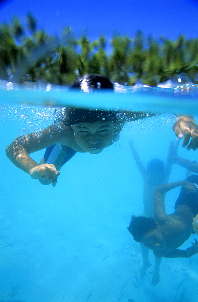 Children swimming under water, diving, Takapotu, Tuamotu Islands, French Polynesia, South Pacific