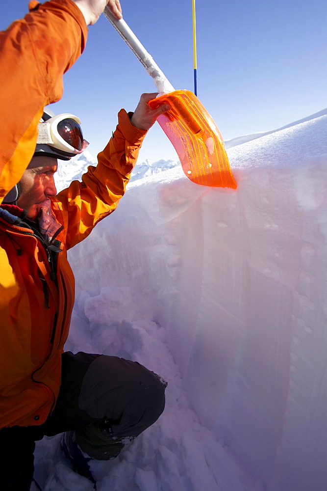 Mountain guide shoveling snow, checking danger of avalanches, Bavaria