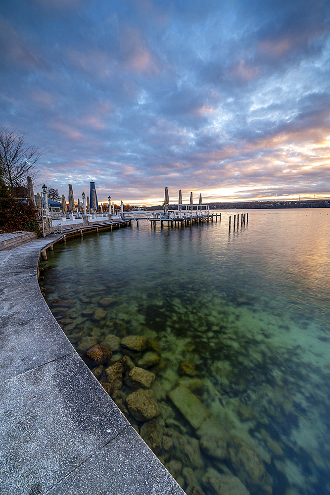 Sunrise on the promenade with a view of the beach bar on the north shore of Lake Starnberg, Starnberg, Bavaria, Germany.