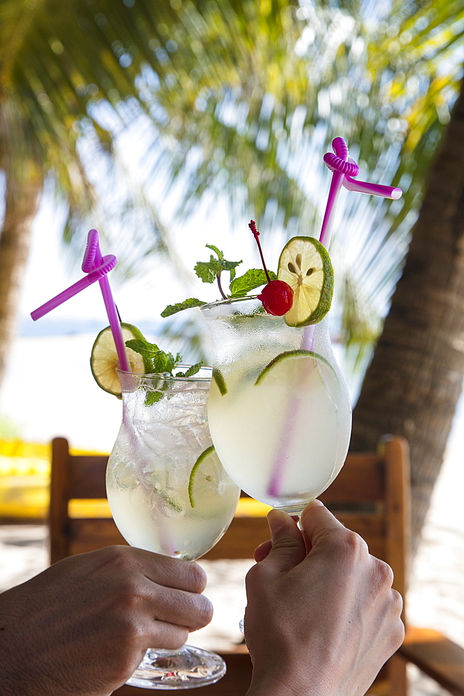 Hands holding two cocktail glasses with fresh lime juice in the restaurant and bar of the Ancarine Beach Resort on Ong Lang Beach, Ong Lang, Phu Quoc Island, Kien Giang, Vietnam, Asia