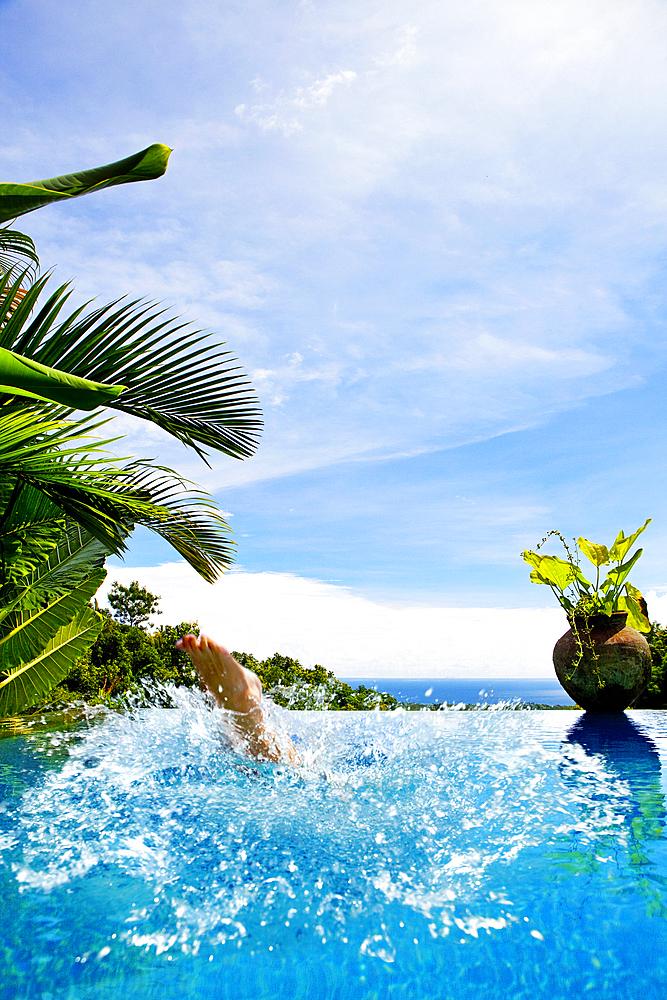 Woman´s feet as she splashes into a pool. Bali, Indonesia