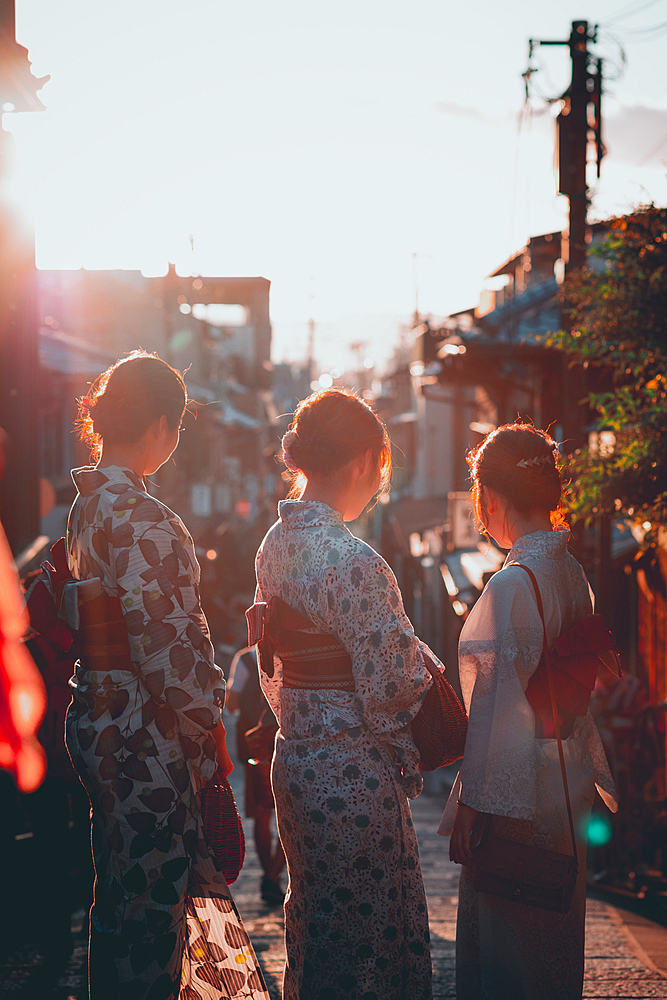 Women in the evening sun dressed in kimonos Kyoto, Japan