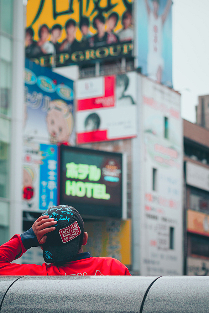 Youngster leans against a bridge in Dotonbori. Osaka, Japan