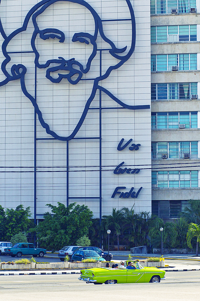 Building with image of Fidel Castro and classic car on Plaza de La Revolución in Havana, Cuba