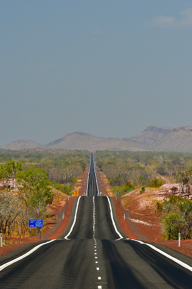 The highway runs lonely in the heat through the outback, Kununurra, Western Australia, Australia