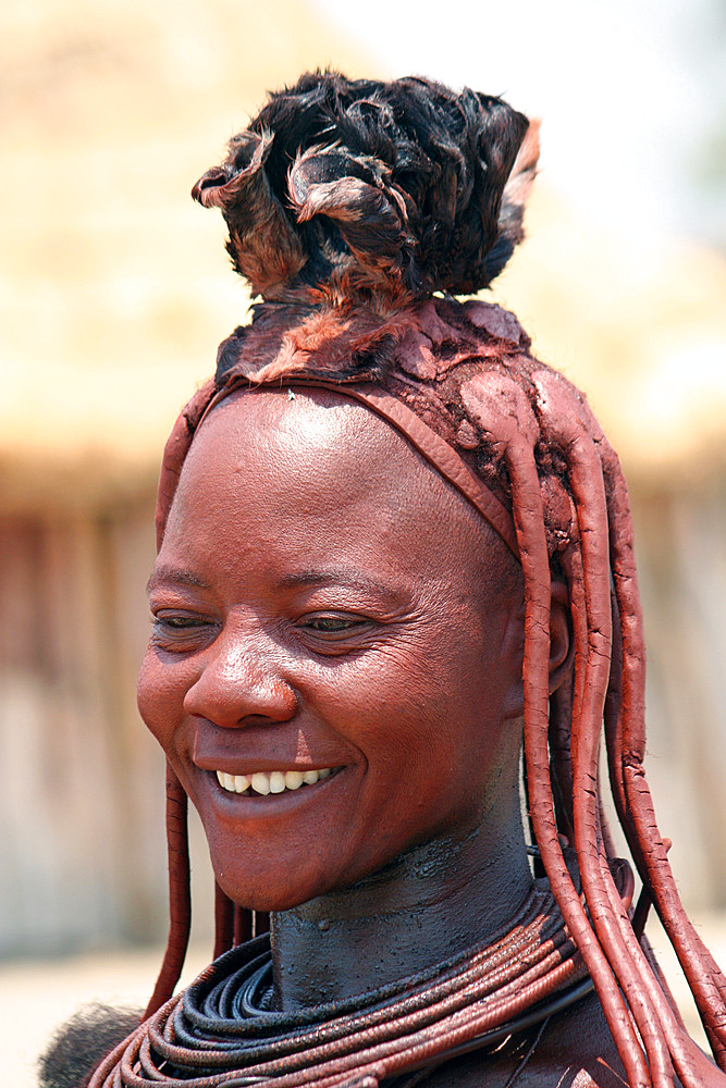 Angola; southern part of Namibe Province; Muhimba woman with traditional hair styling; Strands of hair stuck together with red earth and fluffy fur