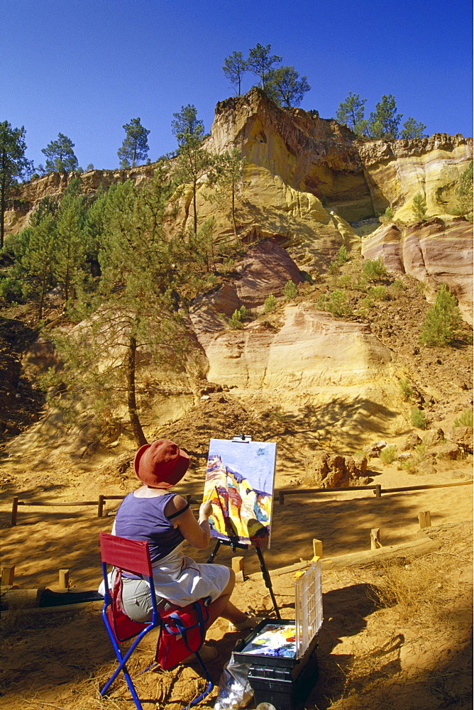 Paintress with easel at the ochre rocks at Val de FÃˆes under blue sky, Vaucluse, Provence, France, Europe